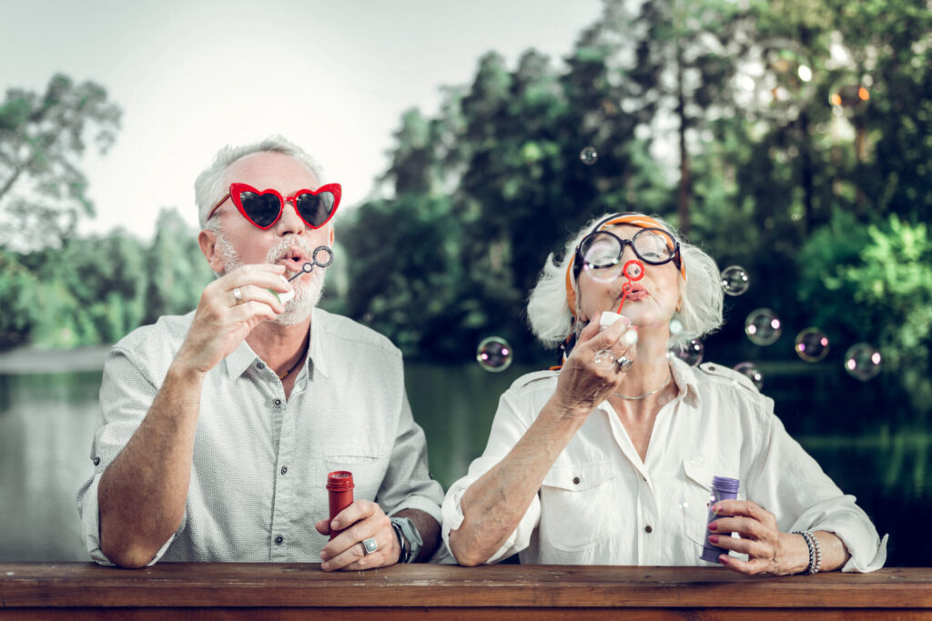 Happy retired couple from the Baby Boomer generation blowing bubbles. 