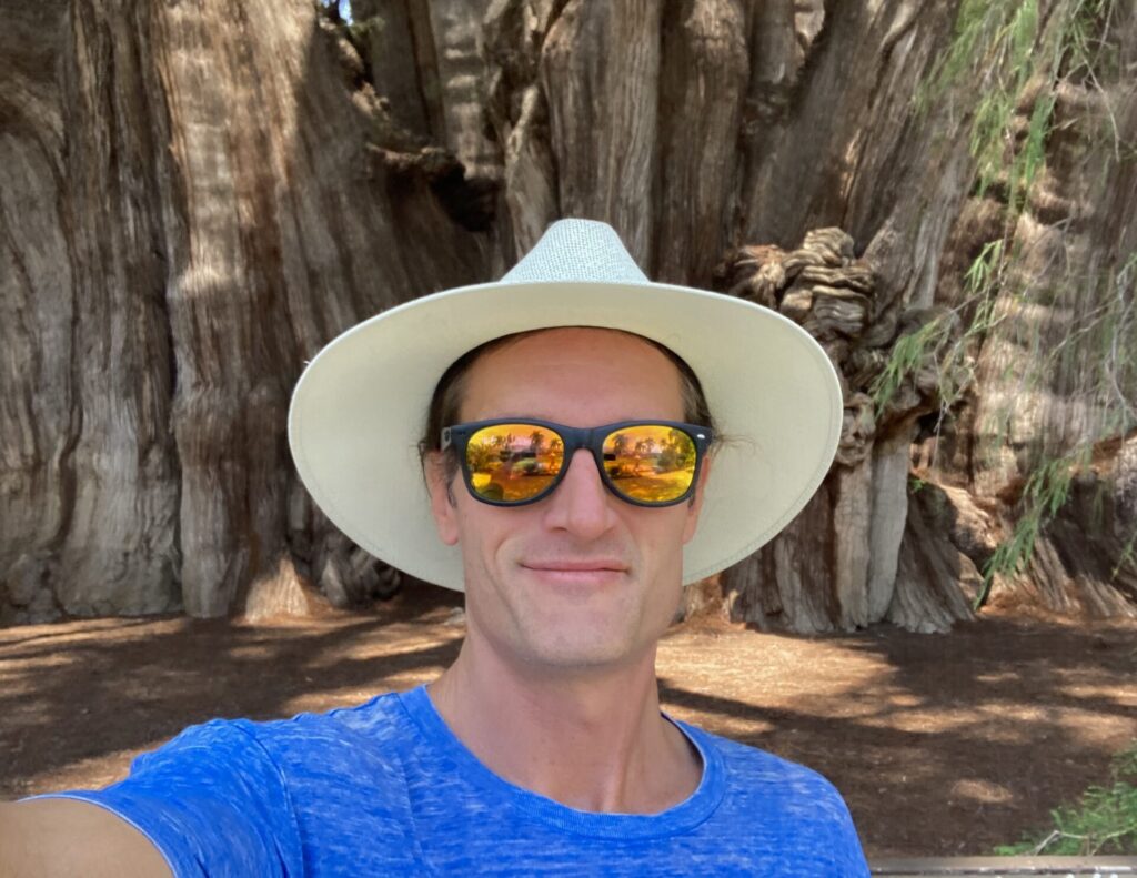 G. K. Hunter founder of Gen Unison standing in front of El Tule in Oaxaca, the world's widest tree. 